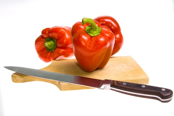 Wooden cutting board, knife and pepper — Stock Photo, Image