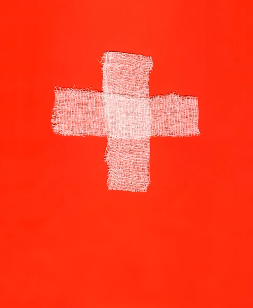 stock image White bandages forming a cross on red