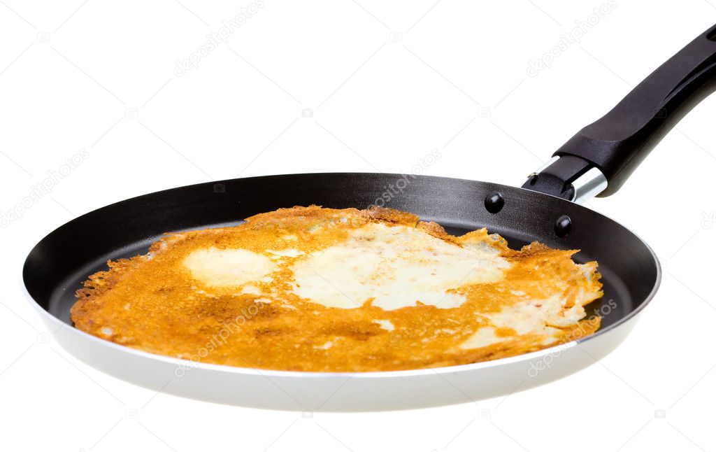 Pancake cooking in a pan on white