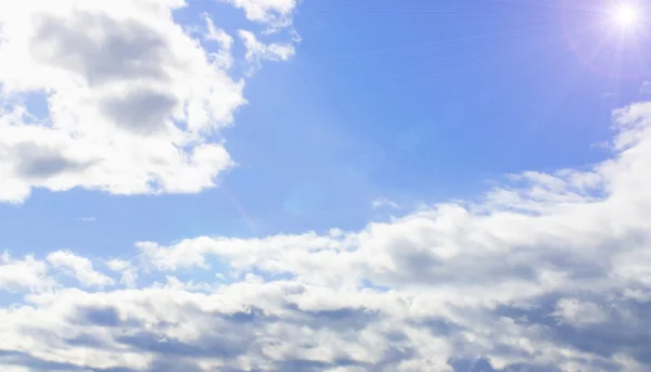 Blue sky with clouds and sun — Stock Photo, Image