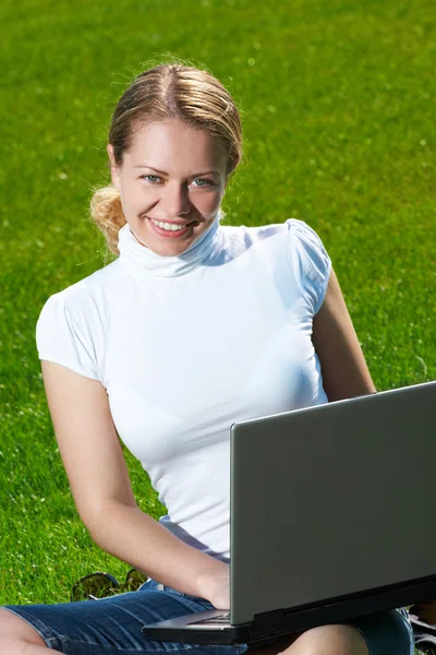 Yeşil çim üstünde laptop ile kız — Stok fotoğraf