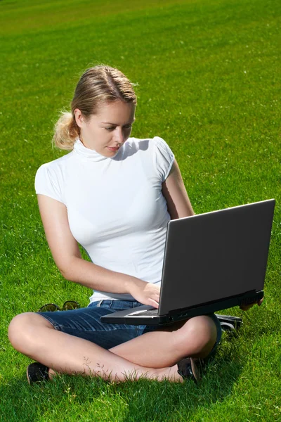 Το κορίτσι με το φορητό υπολογιστή για ένα πράσινο γκαζόν — Φωτογραφία Αρχείου
