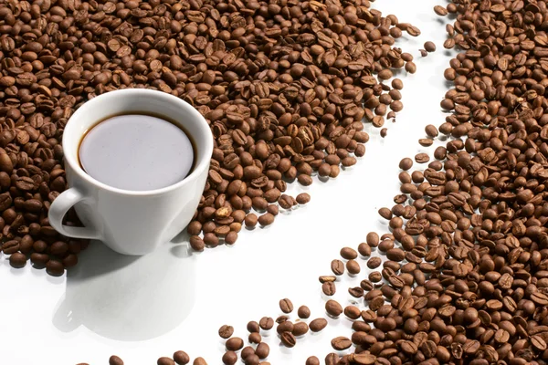Kubek z kawą, kosztuje na ziarna kawy — Zdjęcie stockowe