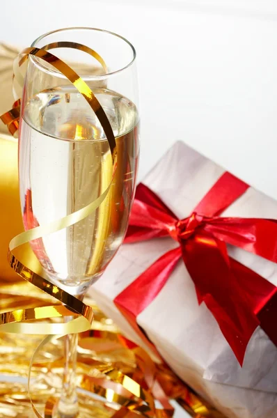 Copo de champanhe, presente com fitas vermelhas — Fotografia de Stock