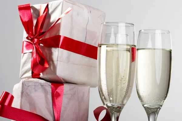 Glazen van champagne, geschenken — Stockfoto