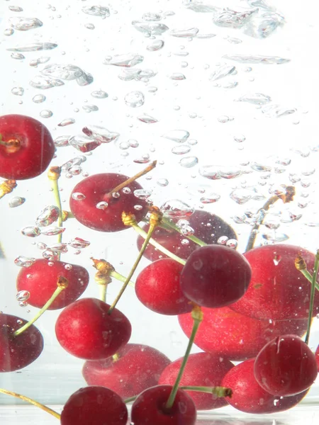 Cherries falling in water — Stock Photo, Image