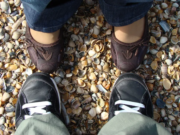 Schoenen bijeenkomst op het strand Stockfoto