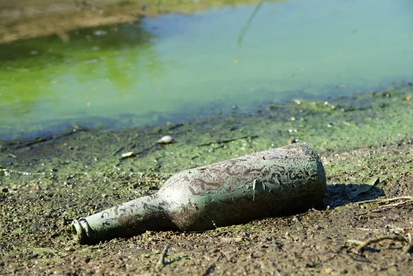 Smutsiga flaska på stranden — Stockfoto