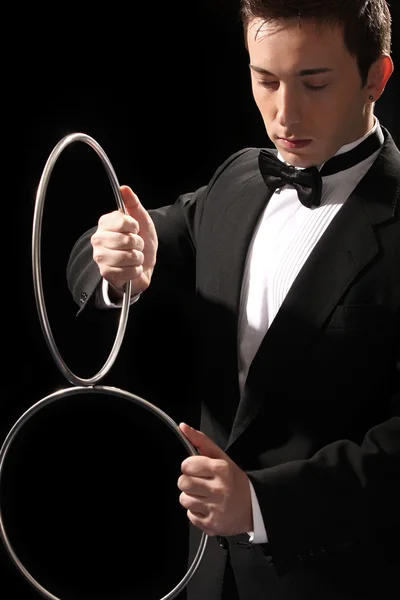 Mladý kouzelník s stříbrné kovové kroužky — Stock fotografie