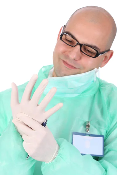 Chirurg nasazuje lékařské rukavice — Stock fotografie
