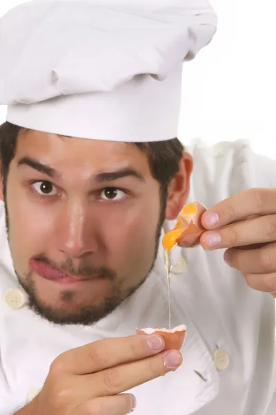 Mladí legrační šéfkuchař popraskání vajíčko — Stock fotografie