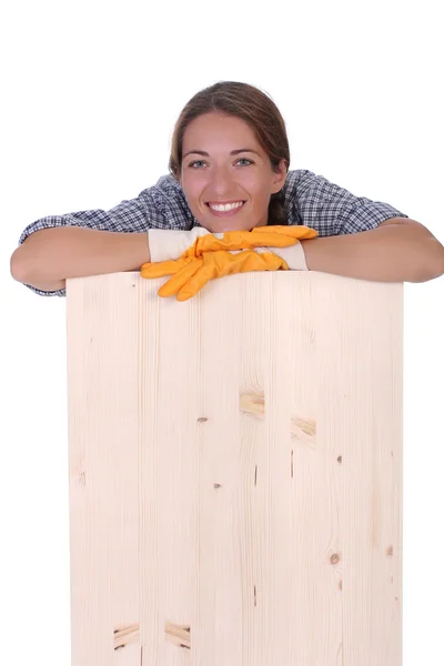 Mulher carpinteiro segurando prancha de madeira — Fotografia de Stock