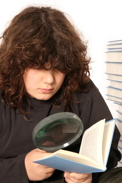 Мальчик читает книгу с объективом — стоковое фото