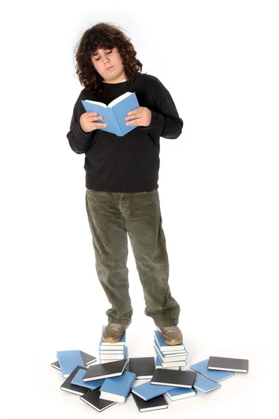 Мальчик на стопке книг — стоковое фото