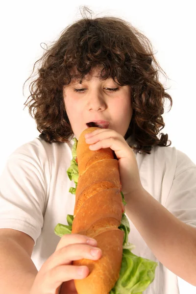 少年は、大きなサンドイッチを食べて — ストック写真