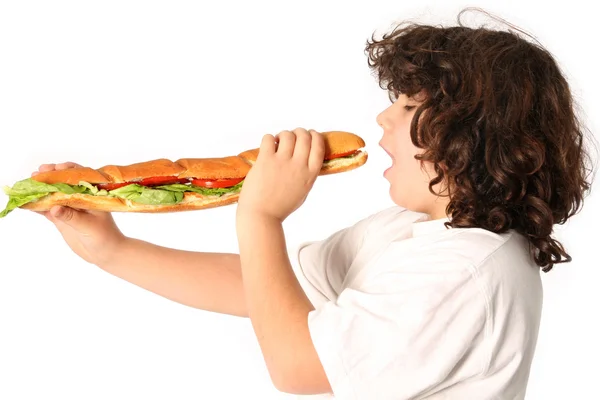 Chlapec jíst velké sendvič — Stock fotografie