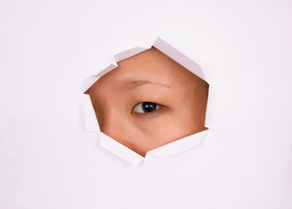 Eye looking through hole — Stock Photo, Image