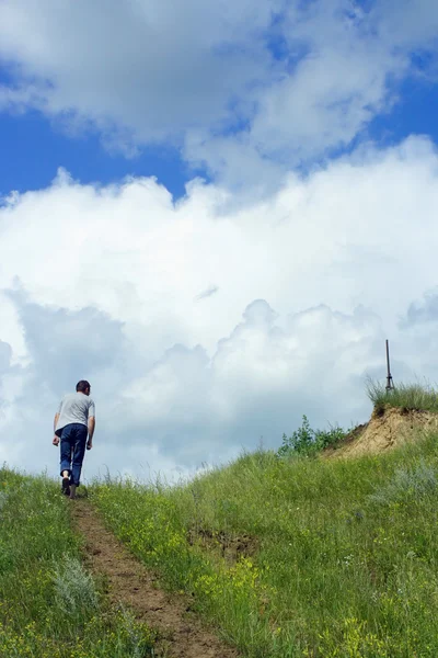 Ein junger Mann erklimmt einen Berg — Stockfoto