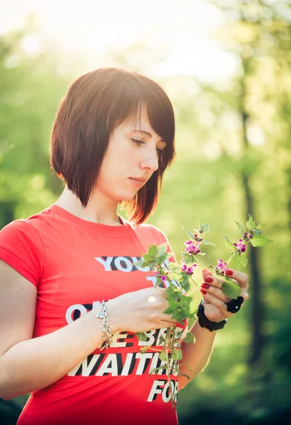 Ładna kobieta trzyma kwiaty wiosny — Zdjęcie stockowe