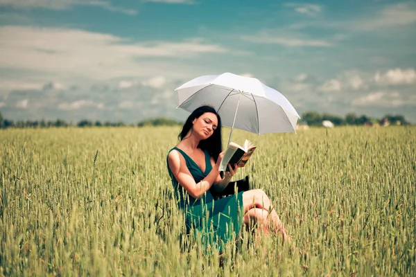 stock image Girl with book under an umbrella