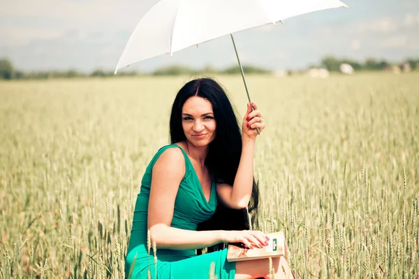 Meisje met boek onder een paraplu — Stockfoto