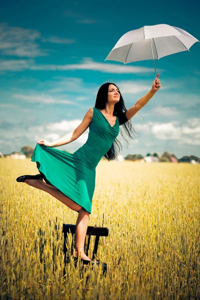 Dívka s deštníkem v poli — Stock fotografie