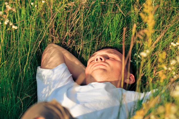 Mladý dospělý muž v jarní tráva — Stock fotografie