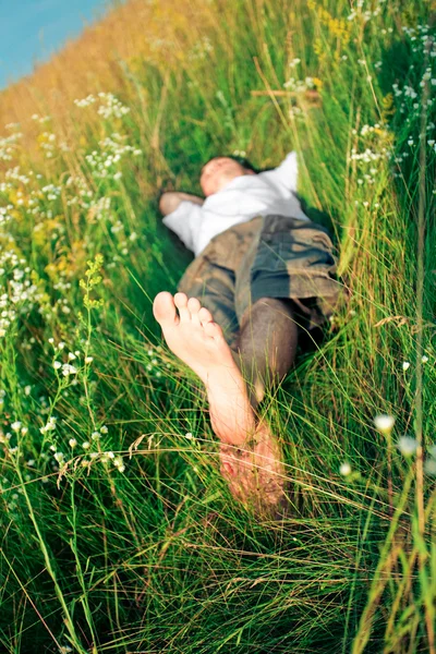 Jovem adulto homem na grama primavera — Fotografia de Stock