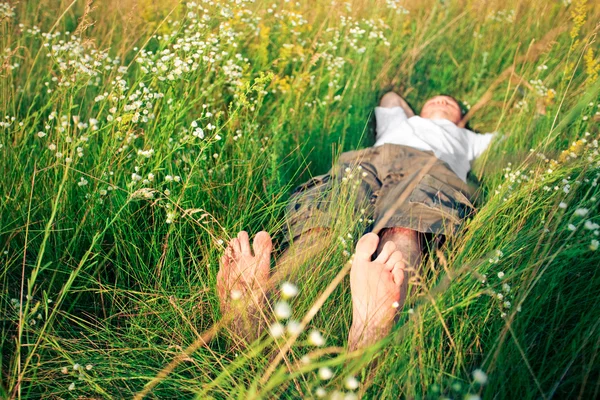 Jovem adulto homem na grama primavera — Fotografia de Stock