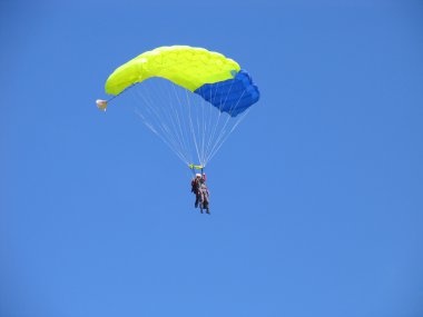 Parachutists in the blue sky clipart