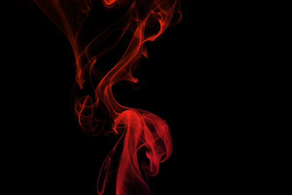 Red smoke curves isolated on black background