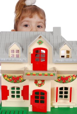 Little girl protruding behind toy house clipart
