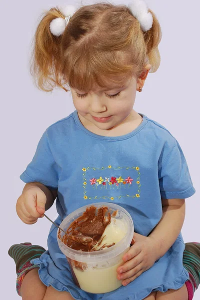 Маленька дівчинка їсть шоколадний крем — стокове фото