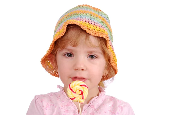 Маленька дівчинка з барвистим капелюхом і льодяником — стокове фото