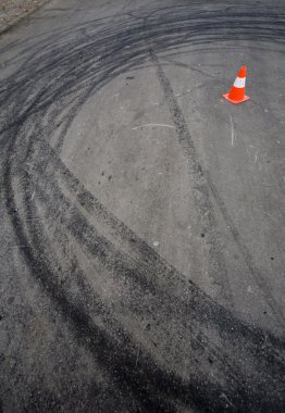 Orange traffic cone and skid marks clipart