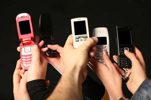 Mobiele telefoons in handen — Stockfoto