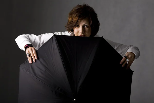 Усміхнена жінка з чорною парасолькою — стокове фото