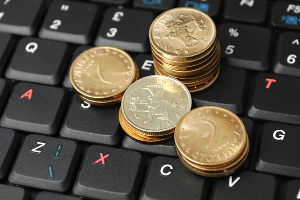 Много монет на клавиатуре с налоговой буквой — стоковое фото