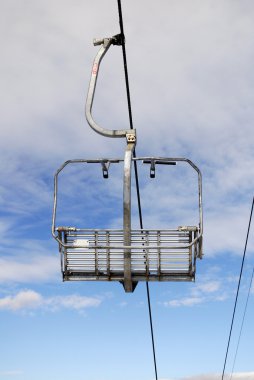 Empty chairlift on blue sky clipart