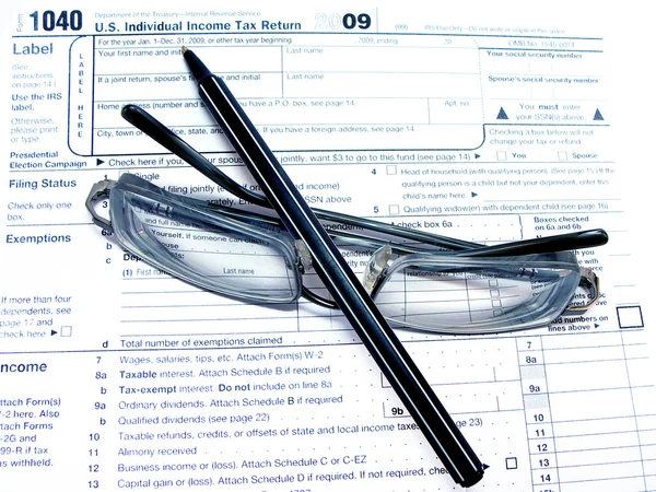 Μια φορολογική μορφή, ένα γυαλιά, ένα στυλό Royalty Free Εικόνες Αρχείου