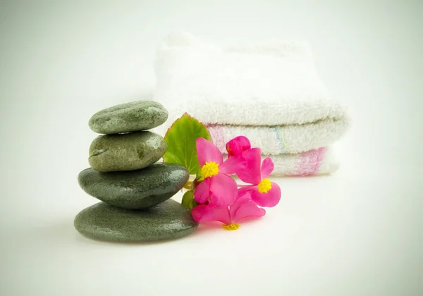Stenar med blomma och handduk — Stockfoto