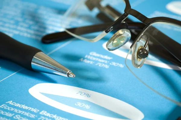 Fountain pen and glasses on stock chart. — Stock Photo, Image