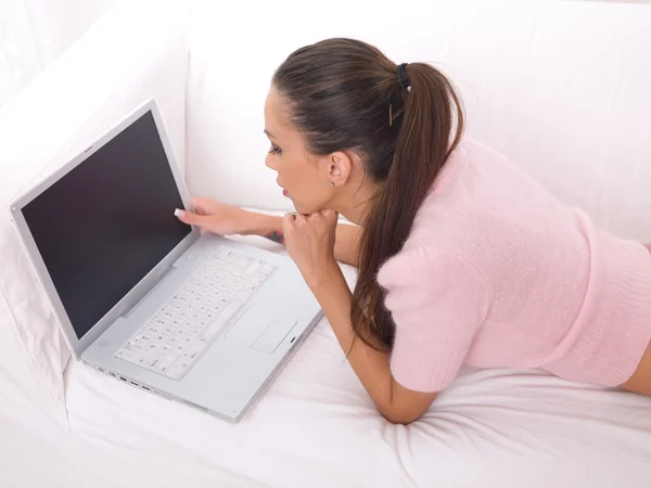 Девушка с ноутбуком на диване — стоковое фото