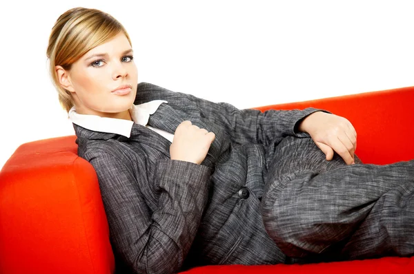 Woman on red couch — Stock Photo, Image