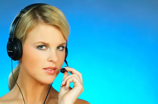 Jovem mulher bonita usando um fone de ouvido de telefone — Fotografia de Stock
