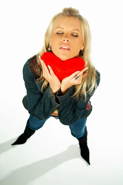 Chica sexy rubia sosteniendo un corazón de terciopelo rojo — Foto de Stock