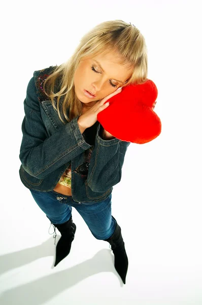 Chica sexy rubia sosteniendo un corazón de terciopelo rojo — Foto de Stock