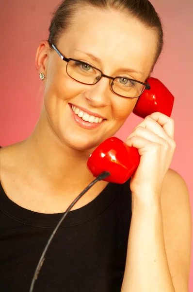 Pretty blonde young women with red classic phone — Stock Photo, Image