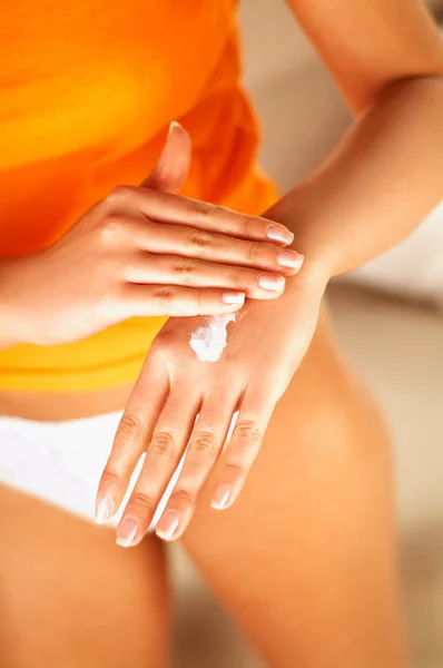 Jonge vrouwen applaying crème op haar huid — Stockfoto