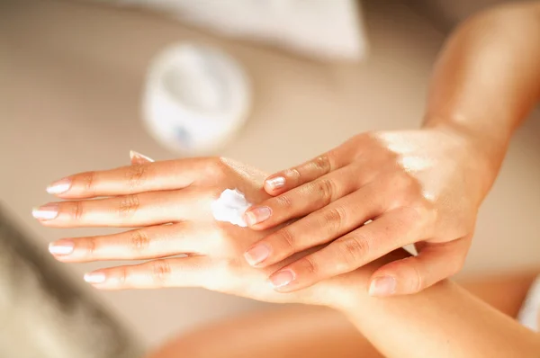 Giovani donne applaying crema sulla sua pelle — Foto Stock